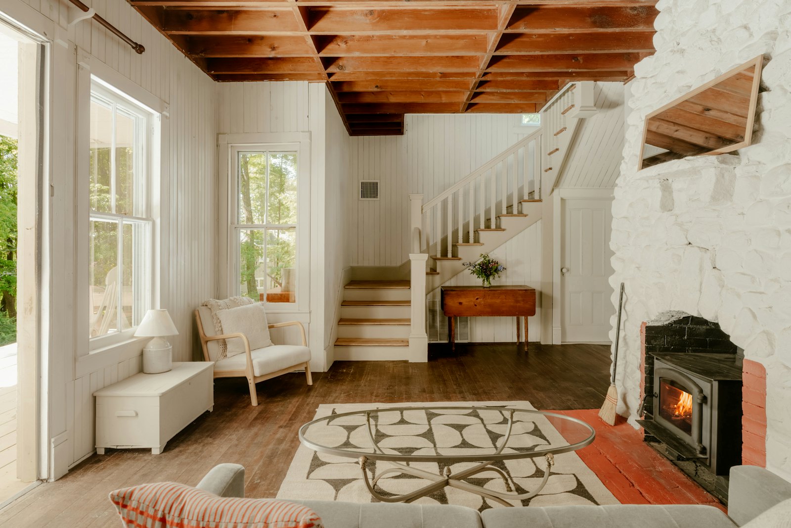 Bright, well-lit cottage living room with fireplace after editing